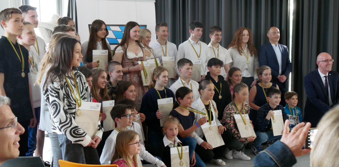 Gruppenfoto mit Urkunden und Medaillen aller bei der Landkreisehrung ausgezeichneten Sportler:innen.