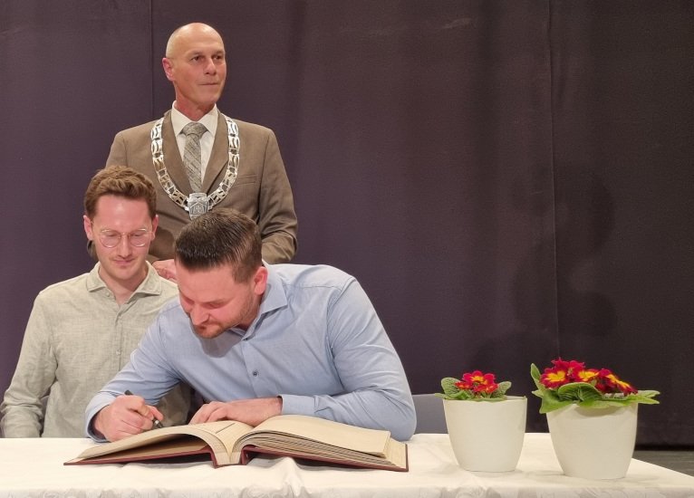 Martin Egarter und Thomas Kieferle tragen sich in das Goldene Buch der Gemeinde Kissing ein.